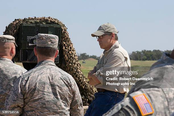 Governor Rick Perry talks with commanders as he views Texas National Guard operations at Camp Swift east of Austin as troops prepare for a 1,000...