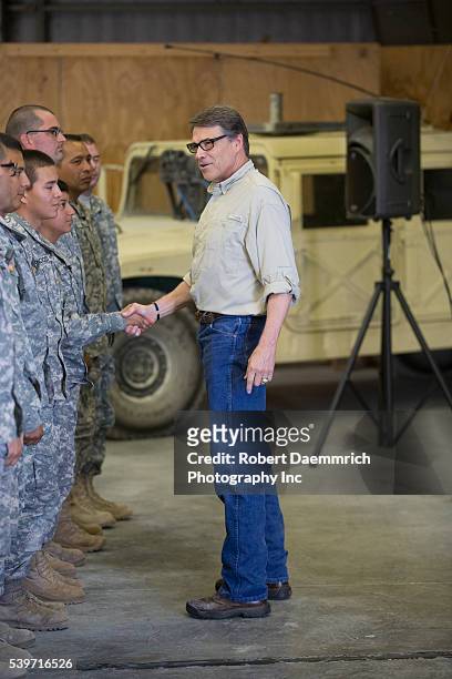 Texas Governor Rick Perry visits with National Guard troops after speaking with them about their upcoming mission as he views operations at Camp...