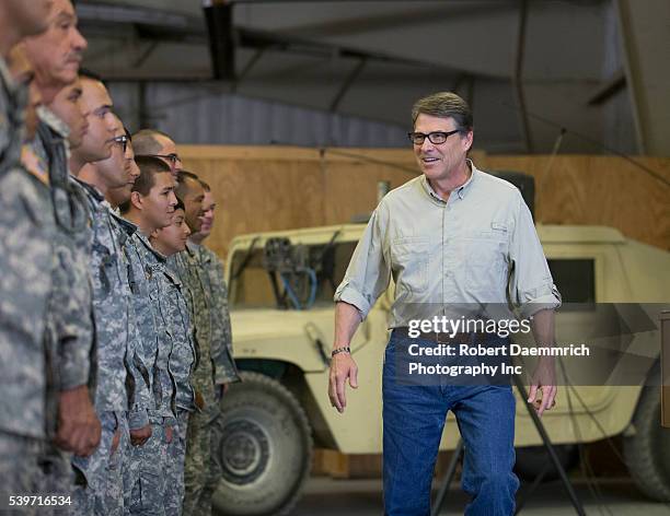 Texas Governor Rick Perry visits with National Guard troops after speaking with them about their upcoming mission as he views operations at Camp...