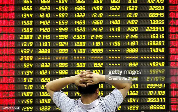 An investor watches the eclectic monitor at a stock exchange in Huaibei, Anhui province, China on 24th August 2015.Chinese stocks plummeted Monday,...