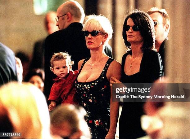 Paula Yates holds her daughter Heavenly Hiraani Tiger Lily in her arms and is comforted by her friend Belinda Brewin during the church funeral...