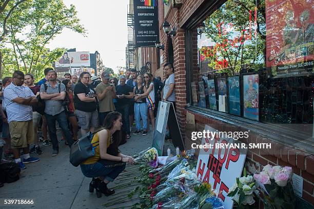 Mourners lay flowers during a vigil in reaction to the mass shooting at a gay nightclub in Orlando, Florida,in New York on June 12, 2016. Fifty...