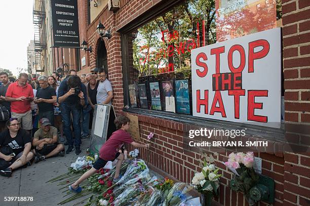 Brown-Spino lays a paper flower during a vigil in reaction to the mass shooting at a gay nightclub in Orlando, Florida,in New York on June 12, 2016....