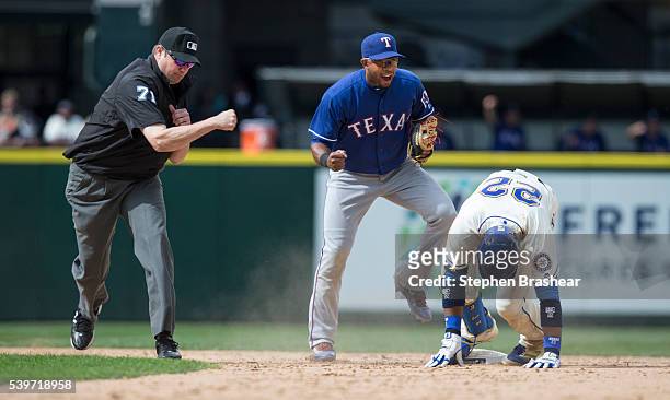 Shortstop Elvis Andrus, center, celebrates a victory after tagging out Robinson Cano of the Seattle Mariners at second base while second base umpire...