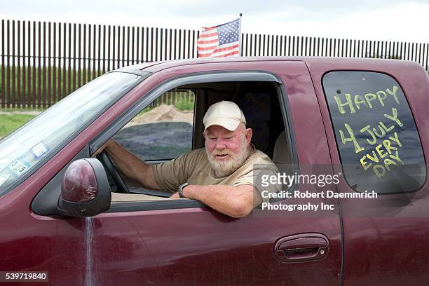 Militia member and landowner Rusty Monsees, Jr. Of Brownsville, Texas sits in his pickup next to his land by the border wall in south Texas. Monsees...