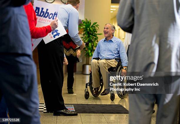 Texas governor candidate Greg Abbott arrives to address cheering supporters at an executive aviation terminal after campaigning state wide on the eve...