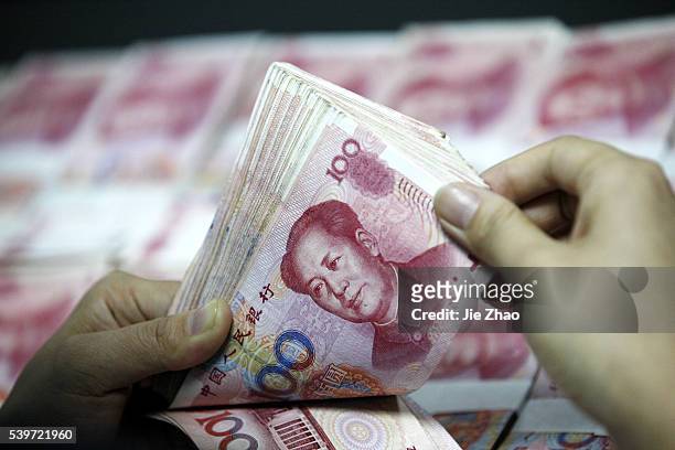 Chinese clerk counts RMB yuan banknotes at a bank in Huaibei , Anhui province, China 1 December 2015.The International Monetary Fund agreed Monday to...