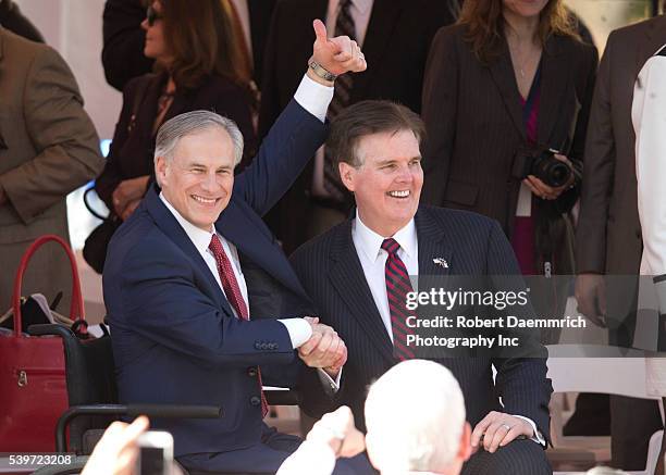 Texas Governor Greg Abbott, l, congratulates his colleague Lt. Gov. Dan Patrick as the two view the inaugural parade in downtown Austin. Abbott...