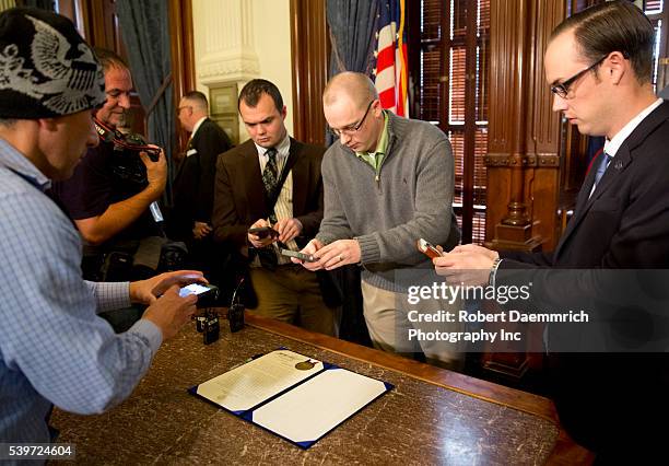 February 2nd, 2015 Austin, Texas USA: Members of the media take photos and video of proclamation signed by Texas Governor Greg Abbott as February...