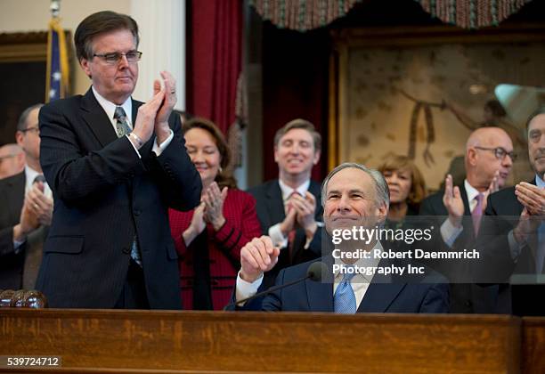 Lt. Gov. Dan Patrick applauds as Texas Governor Greg Abbott, r, gives his first State of the State speech since becoming governor after Rick Perry's...