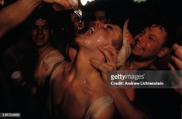 Students from the State University of New York in Albany chug cups of beer at a party.