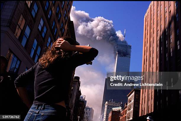 Shocked crowds of downtown Manhattanites observe the burning World Trade Center towers in New York City early September 11, 2001. Three hijacked...