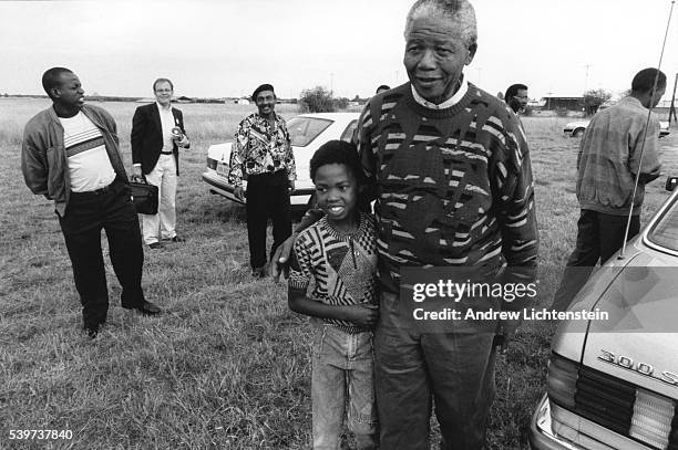 Presidential candidate and African National Congress leader Nelson Mandela greets a young supporter while campaigning through the villages where he...