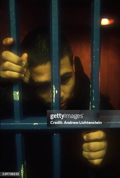 Young suspect waits behind bars to be processed before being transferred to the city jail downtown. In the mid-1990s, East Bridgeport became a...