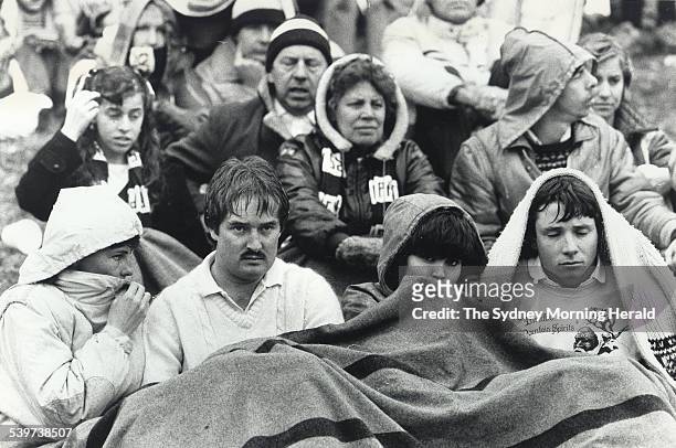Fans sit under blankets looking dejected during the rugby league match between Penrith and Manly in Penrith, 27 July 1986. SMH Picture by ROBERT...
