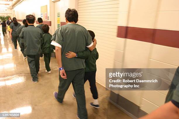 Alien families and their children walk along the halls of the T. Don Hutto Residential Center in Taylor, Texas. The center, an Immigration and...