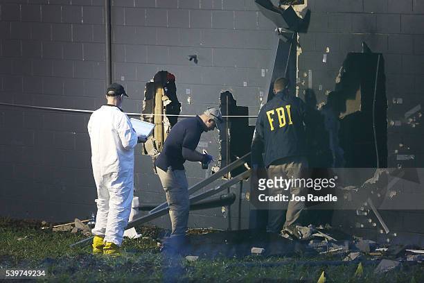Agents investigate near the damaged rear wall of the Pulse Nightclub where Omar Mateen allegedly killed at least 50 people on June 12, 2016 in...