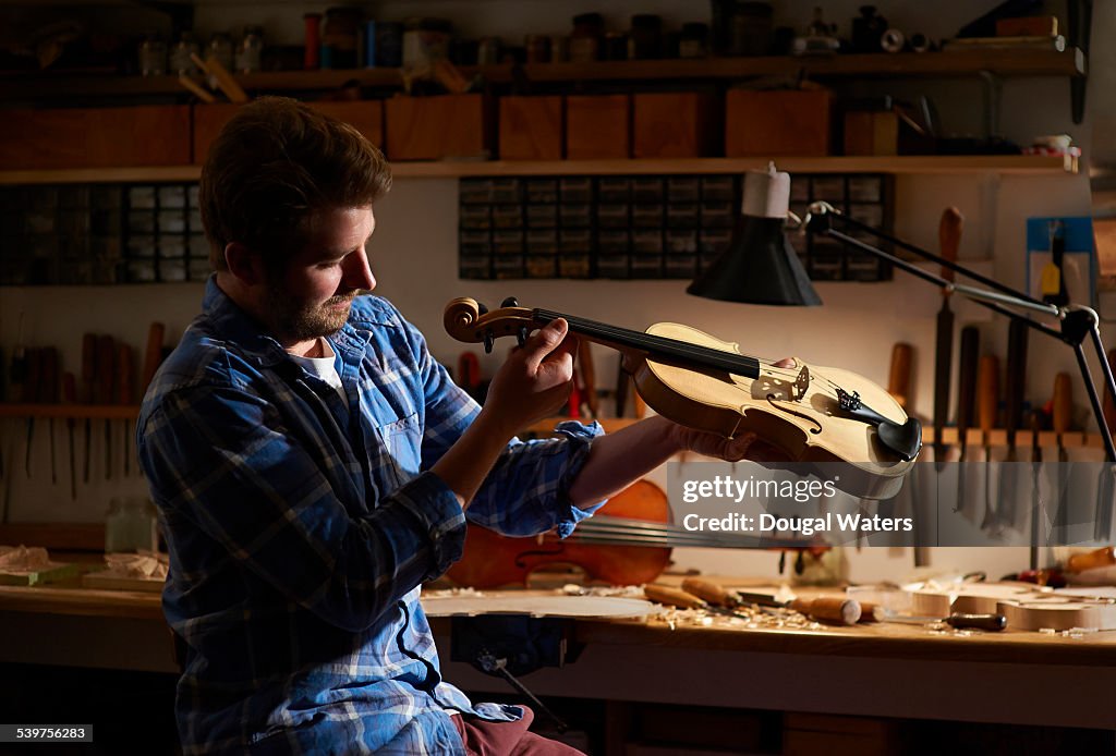 Violin maker checking his work.