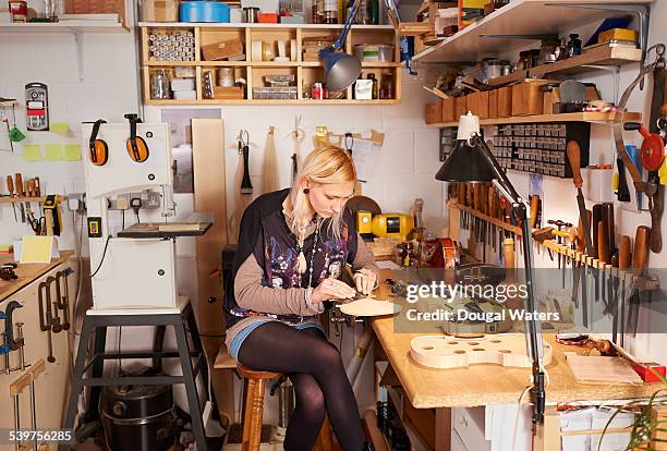 female violin maker in workshop. - make music day fotografías e imágenes de stock