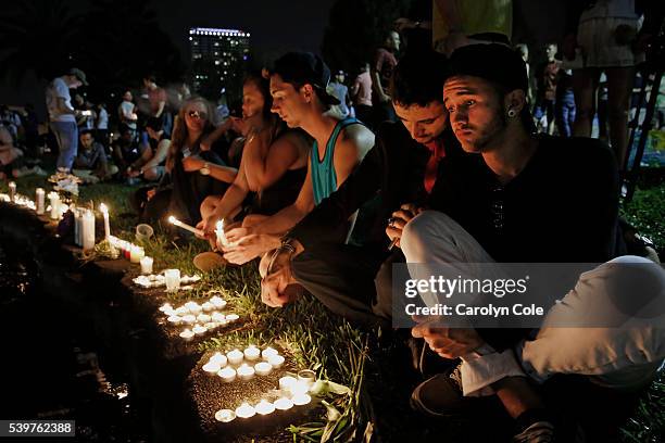 Johnpaul Vazquez, right, and his boyfriend Yazan Sale, sit by Lake Eola, in downtown Orlando thinking of those killed and injured. "We were supposed...