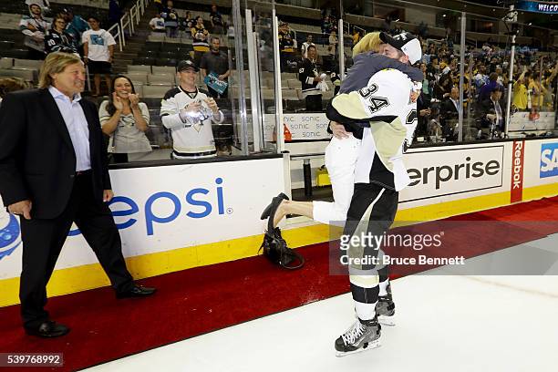 Tom Kuhnhackl of the Pittsburgh Penguins hugs his mother as his father Erich watches after their 3-1 victory to win the Stanley Cup against the San...