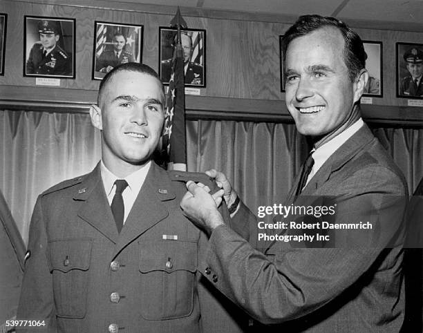 George Herbert Walker Bush poses with his son George W. Bush after he made 2nd lieutenant with the Texas Air National Guard, at Ellington Field near...