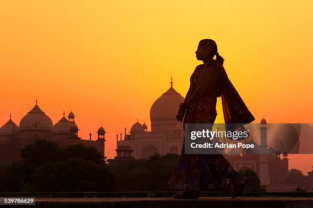 indian woman walking at sunset near taj mahal - india woman stock pictures, royalty-free photos & images