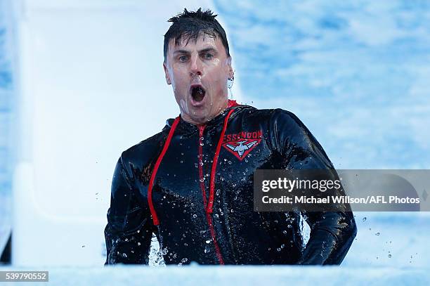 Matthew Lloyd emerges from the water after going down the Freeze MND slide during the 2016 AFL Round 12 match between the Melbourne Demons and the...