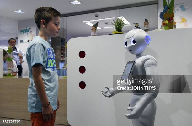 Young boy talks with the robot Pepper during a press conference on June 13, 2016 at the CHR Citadel hospital centers of Liege. - the CHR Citadel...
