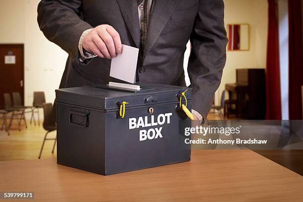 suited man casting his vote - ballot box stock pictures, royalty-free photos & images