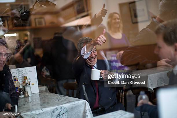 Leader Nigel Farage gestures to a member of the public while sitting down in a cafe for a cup of tea, during a walk about on June 13, 2016 in...