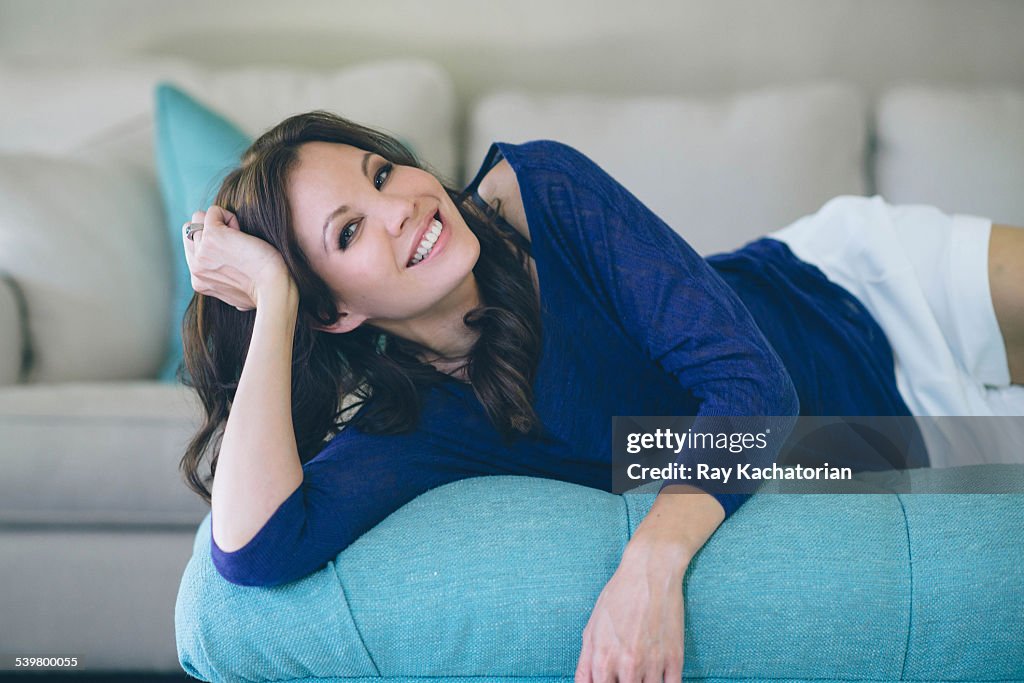 Woman laying on couch smiling