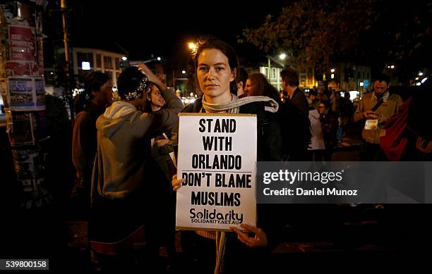 Woman holds a banner during a candlelight vigil for the victims of the Pulse Nightclub shooting in Orlando, Florida, at Newtown Neighbourhood Centre...