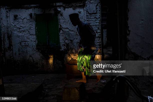 Student is silhouetted as he walks at the islamic boarding school Lirboyo during the holy month of Ramadan on June 11, 2016 in Kediri, East Java,...