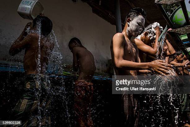 Students take a shower at the islamic boarding school Lirboyo during the holy month of Ramadan on June 10, 2016 in Kediri, East Java, Indonesia. The...