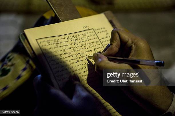 Student writes in Arabic as they learn Islamic scriptures at the islamic boarding school Lirboyo during the holy month of Ramadan on June 10, 2016 in...