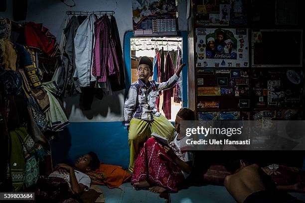 Student, Arik , sits on the window of his room at the islamic boarding school Lirboyo during the holy month of Ramadan on June 9, 2016 in Kediri,...