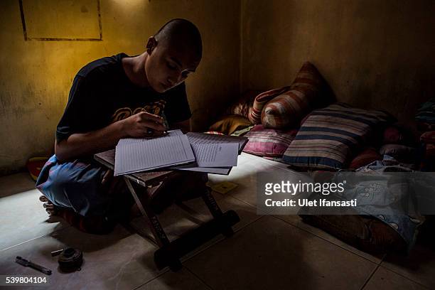 Student writes in Arabic inside his room at the islamic boarding school Lirboyo during the holy month of Ramadan on June 9, 2016 in Kediri, East...