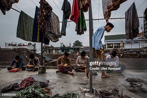 Students learn Islamic scriptures on the roof top in the islamic boarding school Lirboyo during the holy month of Ramadan on June 9, 2016 in Kediri,...