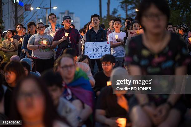 Members of South Korea's LGBT community hold a candle-light vigil for victims of the Orlando shooting, in Seoul on June 13, 2016. US anti-terror...