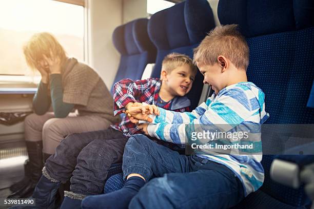 madre que viajan en tren con traviesa niños - lucho en familia fotografías e imágenes de stock