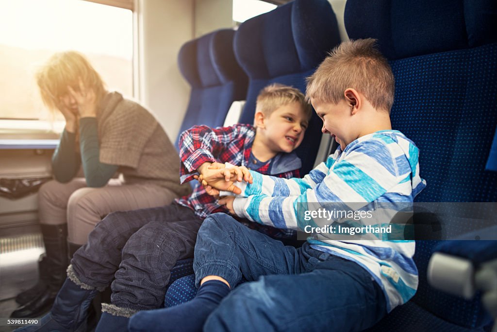 Mother travelling on train with naughty kids