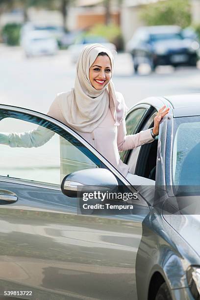 middle easter woman entering a luxury car in dubai - dubai woman driving car stockfoto's en -beelden