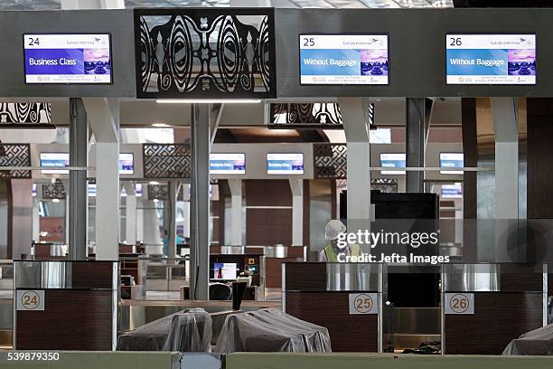Workers acting as passengers gather at the departure lounge during the test run of the new terminal of Soekarno-Hatta International Airport on June...
