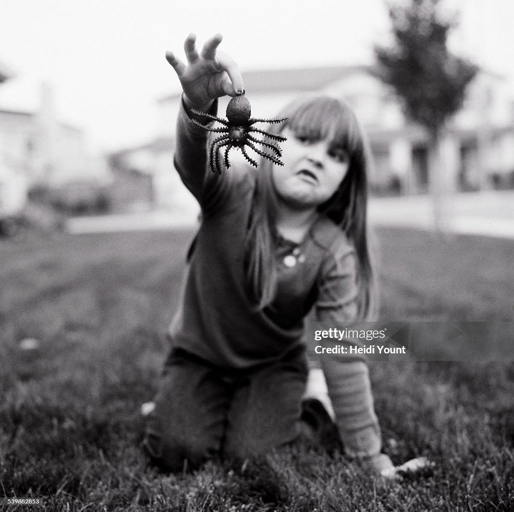 A girl holding a fake spider