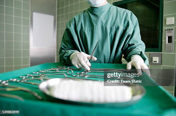 surgeon holding surgical scissors - surgical tray stock pictures, royalty-free photos & images