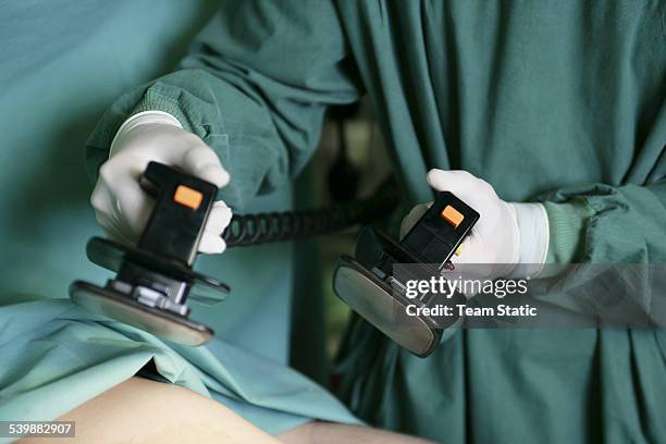 patient being revived by defibrillator machine - desfibrilador fotografías e imágenes de stock