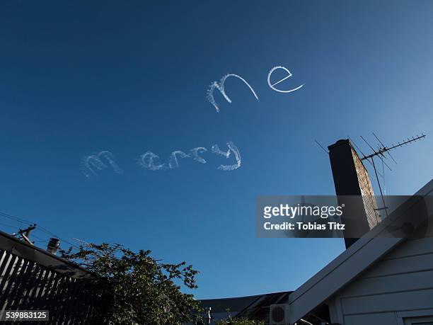 low angle view of marry me written by vapor trails against blue sky - luchtschrift stockfoto's en -beelden
