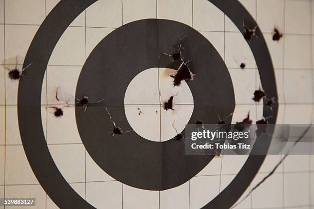 close-up of target with bullet holes - bullet hole target stock pictures, royalty-free photos & images
