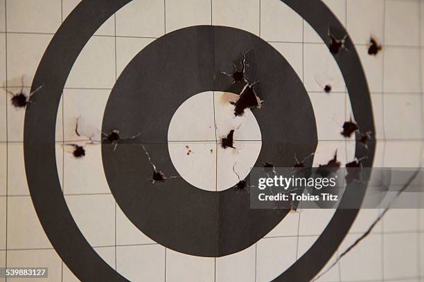 close-up of target with bullet holes - bullet hole stock pictures, royalty-free photos & images